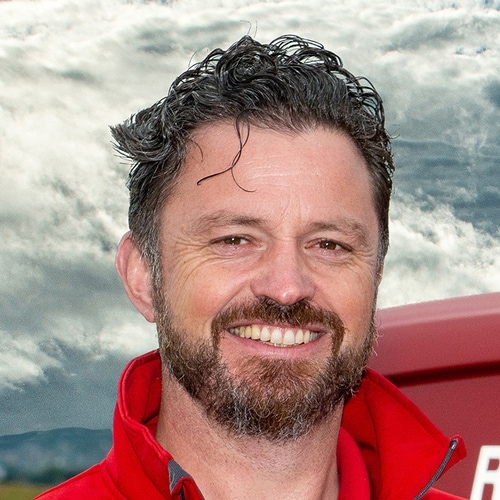 person in a red jacket with cloudy skies in the background